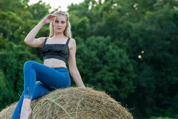 Naklejka na ściany i meble A Lovely Blonde Model Poses Outdoors In A Farm Environment
