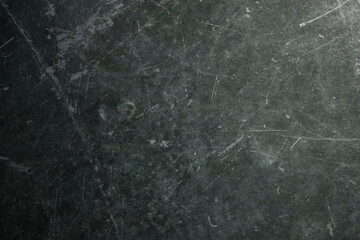 Background texture of used school blackboard, worn, full of grooves, marks, stains. Beaten by time. Dark green. Backdrop.