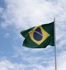 Brazil. Brazilian flag hoisted. Blue sky with clouds, strong wind. Order and progress, legibly in...