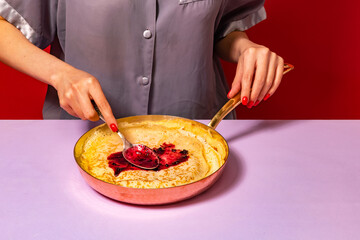 Food pop art photography. Cropped portrait of girl and hot pancakes with jam on lilac color tablecloth. Vintage, retro style interior