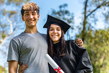 Happy caucasian graduated girl with her boyfriend or her brother on her graduation day