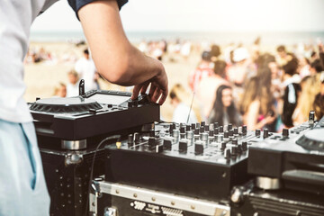 Close up of deejay playing electronic music at summer beach party - Music festival and club party...