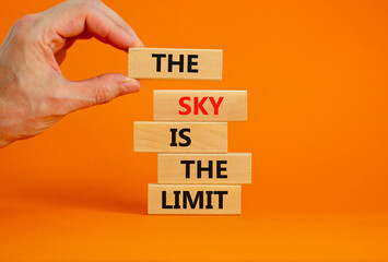 Sky is limit symbol. Concept words The sky is the limit on wooden blocks. Businessman hand. Beautiful orange table orange background. Business motivational stress spice of life concept. Copy space.