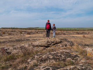Travelers mother daughter raising hands on mountain summit spending time together walking climbing enjoying scenic landscape cloudy sky.Active lifestyle candid family having fun Parenthood Mothers day