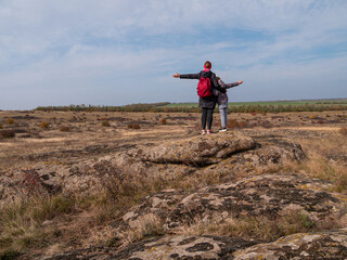 Travelers mother daughter raising hands on mountain summit spending time together walking climbing enjoying scenic landscape cloudy sky.Active lifestyle candid family having fun Parenthood Mothers day