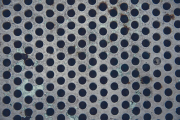 Photography of a metallic surface in the shape of a geometric grid.