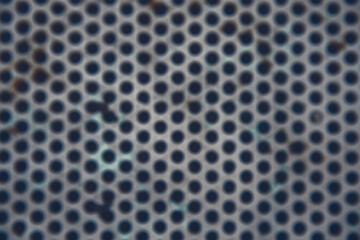 Photography of a metallic surface in the shape of a geometric grid.