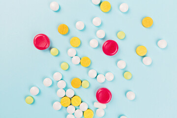 Colorful pills on a pastel blue background. Flat lay, top view, overhead, mockup, template. Pharmacy and medical concept