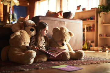 Would you like me to show you the pictures again. Shot of a little girl reading a book with her teddy bears around her.