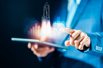 Businessman using tablet computer with glowing rocket space ship with marketing creative innovation process and digital technology