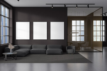 Front view on dark office interior with three white posters