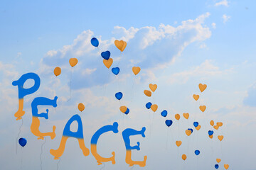 Luftballone in den Ukraine Farbe Blau gelb, und dem Peace Schrifttzug steigen in den Himmel