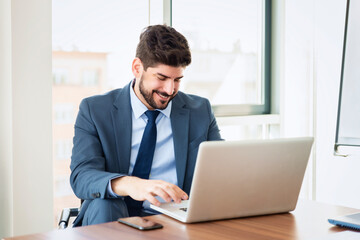 Businessman working on laptop in a modern office