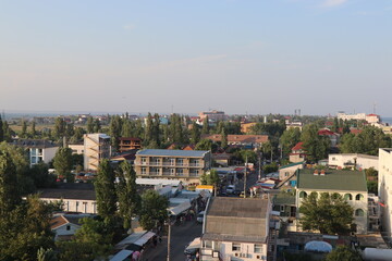 Tall buildings near the sea. The sea coast from a height. Sandy beach. Bright sunset