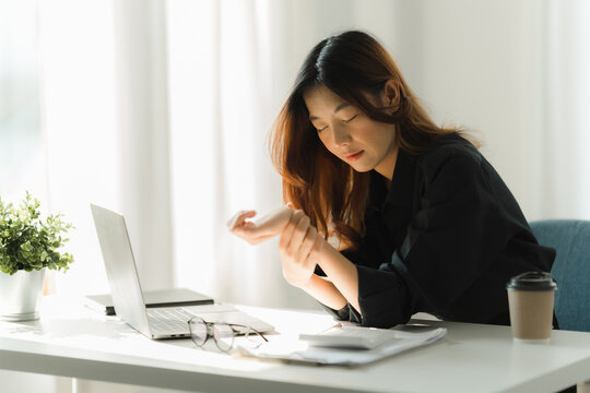 Woman Holding Her Wrist Pain From Using Computer. Office Syndrome