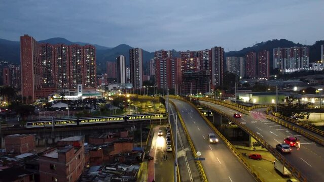 Medellin city at night, light traffic and lights. View of the city subway passing a station. Excellent view of a metropolis