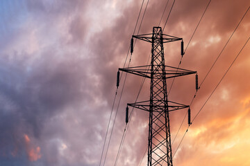 Detail of a British Style Electricity Pylon and suspended electic cables against a Blue Cloudy Sky