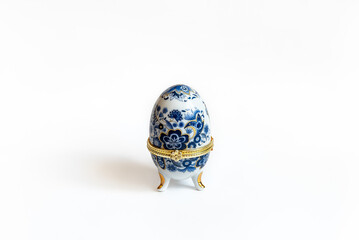 A copy of Faberge egg jewelry trinket box in white and blue colors on a white background
