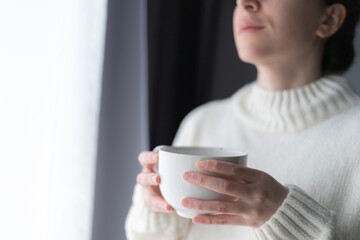 close up of woman's hands holding a big white cup of tea or coffee