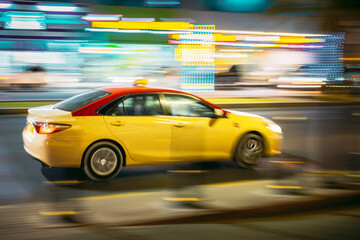 Fototapeta na wymiar Speeding Taxi Car Fast Driving In City Street. Motion Blur Background.