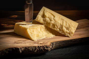 Close up of Quebec Cheddar Cheese on a Wood Board with a Cheese Knife