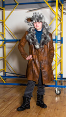 Fototapeta na wymiar Young man in a leather coat with a fur collar.