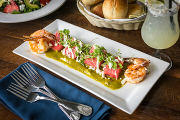 Feta Watermelon Salad with Shrimp, Microgreens, and Pesto on a Rectangular White Plate