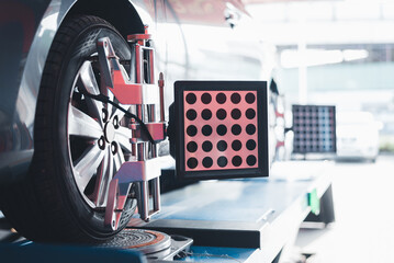 Closed up of an auto wheel : wheel alignment. Balancing tire wheel machine. Tyre assembling. Tire...