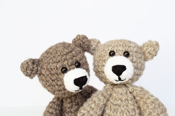 Crocheted gray and brown bears on a white background. Crocheted toy.