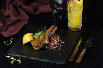 Pork loin with stewed cabbage and baked apple. Main dish in a restaurant on a black background.