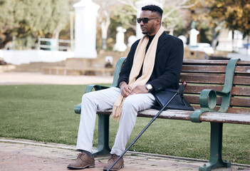 Fototapeta premium Insanity and genius is measured only by success. Shot of a young man sitting on a bench in a park.