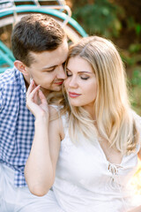 Fototapeta premium Beautiful girl and guy sitting in the Park on the grass.