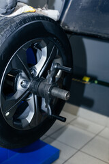 Auto mechanic balances the car wheel on the wheel balancer