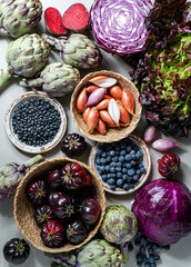 purple and red, violet vegetables on the purple background, top view. purple  artichoke, tomatoes, oniones, blueberries, salad, contain Anthocynins, found in the Okinawan diet, that maintain health