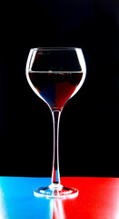 A glass of young wine on a black background.