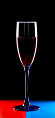 A glass of young wine on a black background.