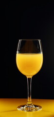 Glass of orange juice on a black background.