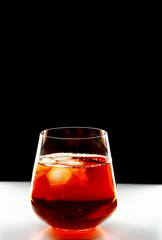 Glass of whiskey with ice on a black background.