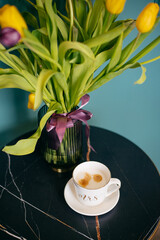 yellow and purple tulips and a cup of coffee on the table