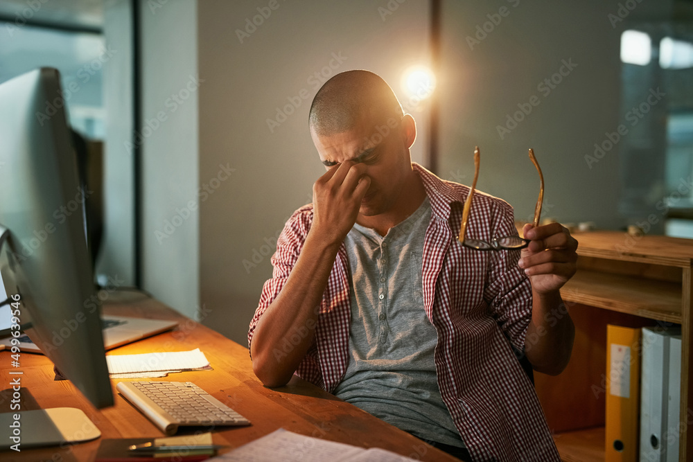 Wall mural struggling to stay awake. cropped shot of a young designer looking stressed out while working late i