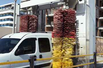 A car goes through an automatic car wash.White car during a car wash