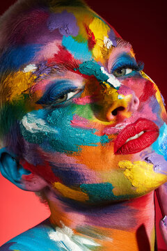 People ask what my favourite colour is and I say all of them. Studio shot of a young woman posing with multi-coloured paint on her face.