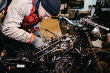 Fototapeta na wymiar motorcycle repair in the garage, service maintenance of motorcycles, repair of the fuel system.