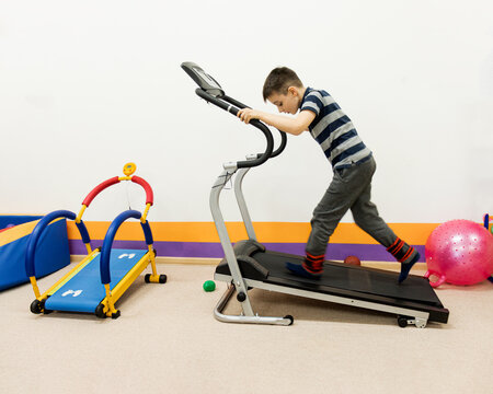 child runs on a treadmill in a children's gym. childrens simulators, sensorics, sensory class,
sensory integration. rehabilitation of sensory disorders,inclusive education, inclusive society.back to s