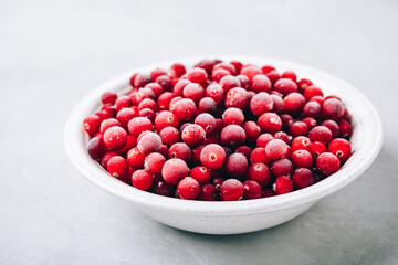 Cranberries. Frozen cranberry in bowl on gray background