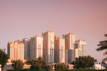 Fototapeta na wymiar New Residential Multi-storey Houses. Cityscape Skyline In Sunny Spring Evening On Pink Sky. Real Estate, Development Industry. UAE.