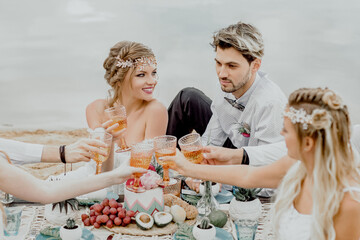 The bride and groom celebrate a happy day with friends in nature outside the city.