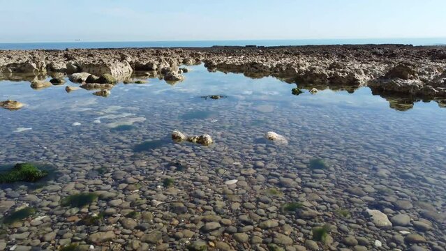 Peacehaven, Sussex - Rocky Beach. 4K Dolly drone footage. Clean, clear rock pools and fossils can be seen.