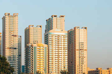 Fototapeta na wymiar New Residential Multi-storey Houses On Blue Sky. Real Estate, Development Industry. UAE.