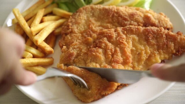 Slicing Breaded Weiner Schnitzel with Potato Chips - Fried Chicken with french fries - European food style